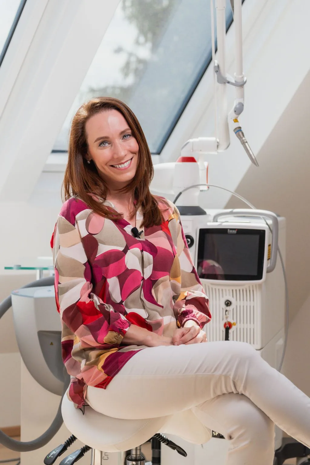 Porträt von Dr. Nicole Egger neben dem Fotona-Lasersystem